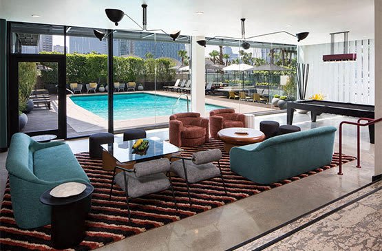 a living room with a pool and chairs and tables at The Flat in Los Angeles, California 90017