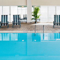 a large swimming pool with chairs on the side of it