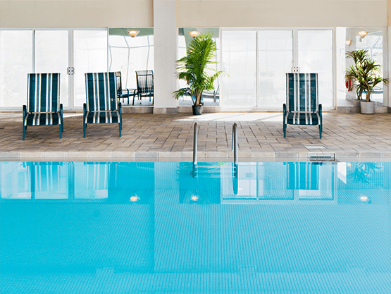 a large swimming pool with chairs on the side of it