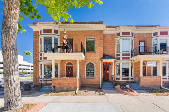 A two-story brick building with a balcony on the second floor.