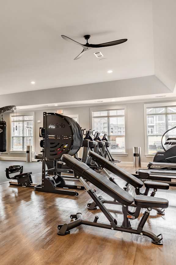 A spacious home gym with a variety of equipment including a punching bag, weight machines, and a pull-up bar.