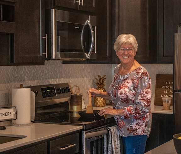 Woman in floral t-shirt is working in kitchen at The Villas at Sand Lake Resort, Sturgeon Lake