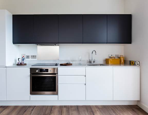 a kitchen with white cabinets and a stainless steel dishwasher