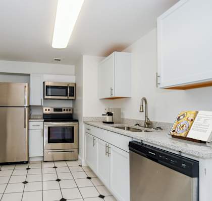 A modern kitchen with white cabinets and stainless steel appliances.