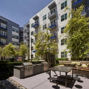 an outdoor patio with a picnic table in front of an apartment building