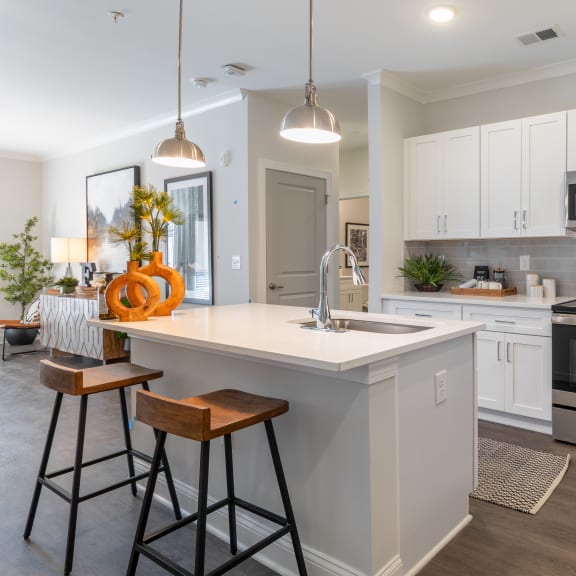 a kitchen with a large island and stainless steel appliances