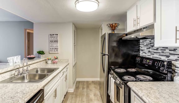 a kitchen with stainless steel appliances and marble counter tops
