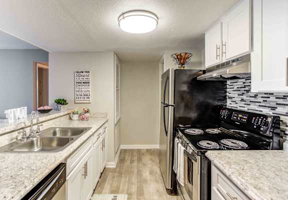 a kitchen with stainless steel appliances and marble counter tops