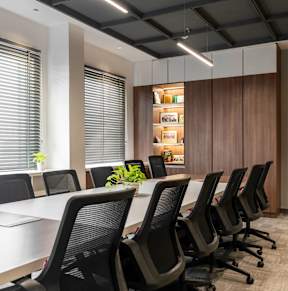 A conference room with a long table and chairs.