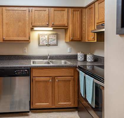 a kitchen with wooden cabinets and stainless steel appliances