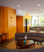 a seating area with couches and tables in front of a large window