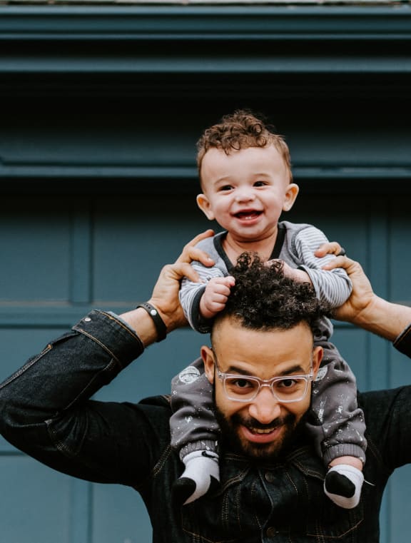 a man holding a child on his shoulders