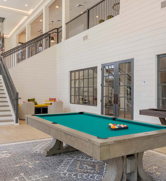 a dining room with a long wood table and chairs at The Quincy Apartments in Acworth, GA 30102