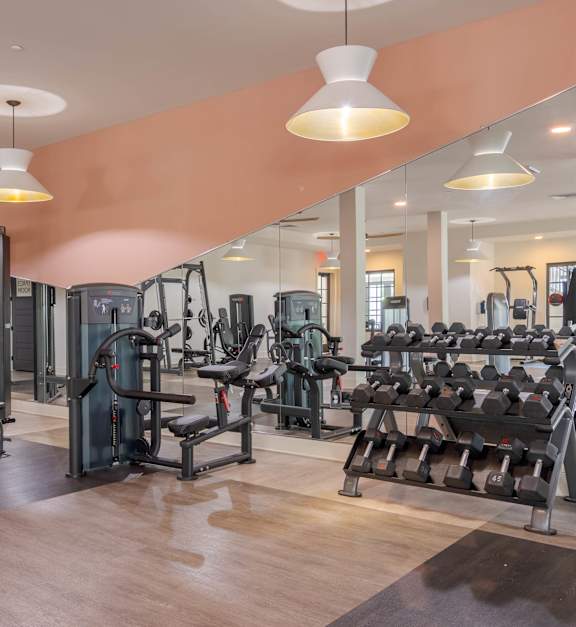 a gym with weights and other exercise equipment on the floor at The Quincy Apartments in Acworth, GA