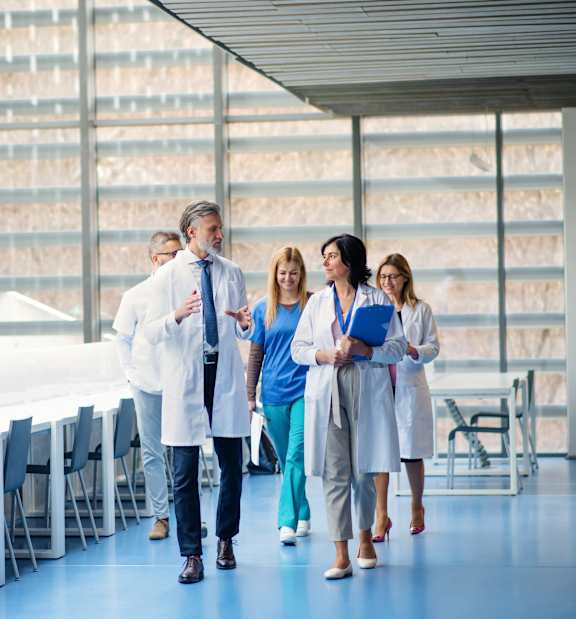 A group of medical professionals walking in a hospital hallway.