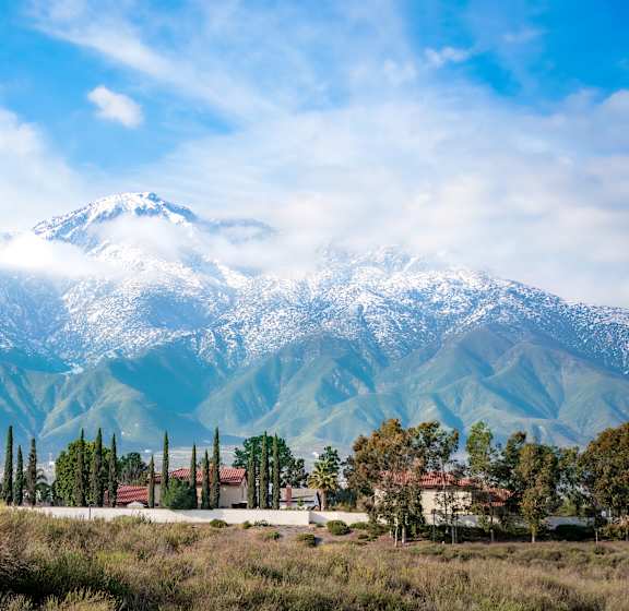 A mountain range covered in snow with a small town in the foreground.