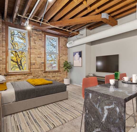 A bedroom with a bed, a table, and a television.
