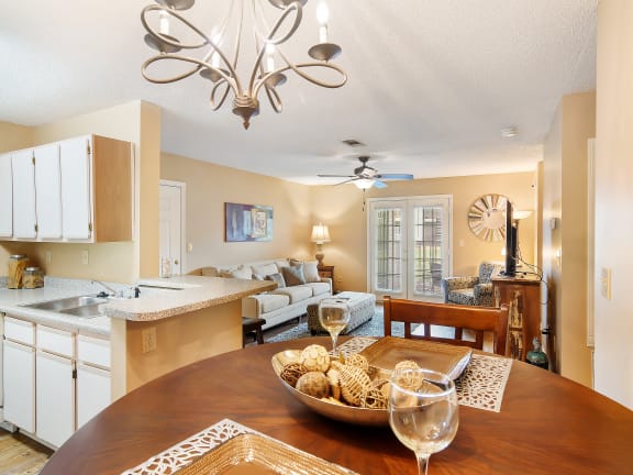 a kitchen and living room with a wooden table at The Colony Apartment Homes, Mississippi, 39702