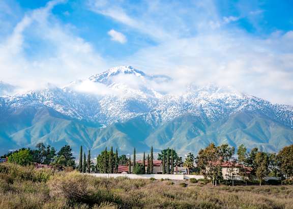 A mountain range covered in snow with a small town in the foreground.