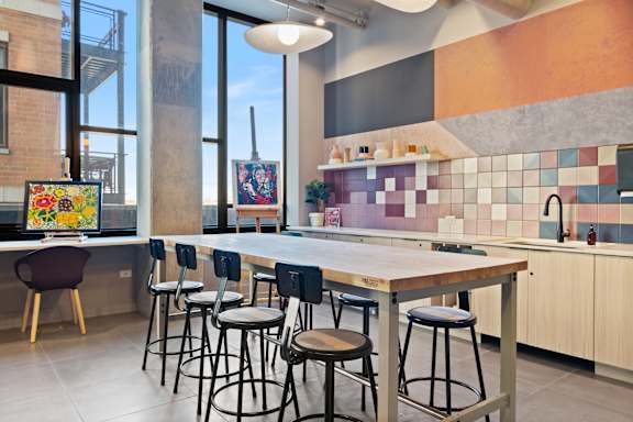 A kitchen with a bar area and a painting on the table.