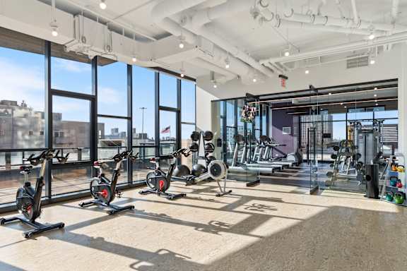 A gym with exercise equipment and a view of the city.