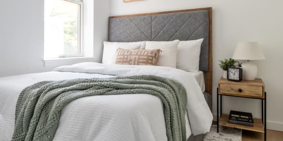 a bedroom with a bed and two paintings on the wall