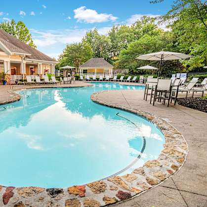 A large swimming pool surrounded by a stone border.