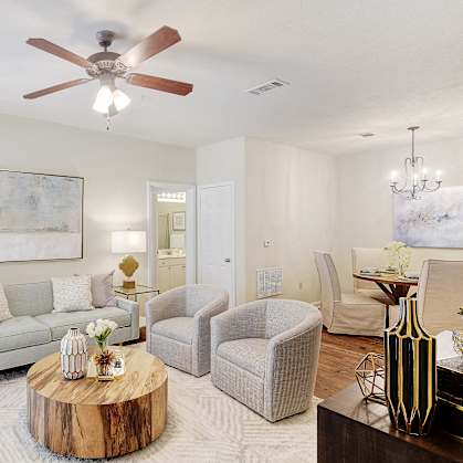 a living room with a couch and chairs and a ceiling fan at Summit of Shreveport Apartments, Shreveport, LA