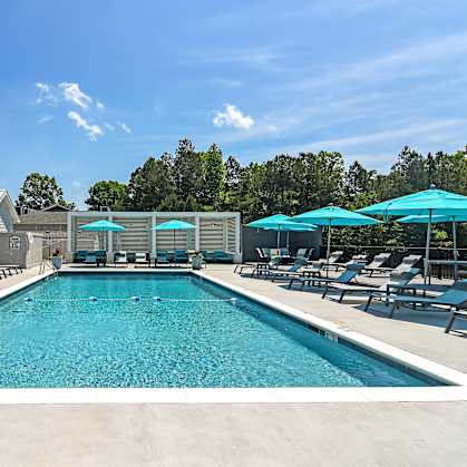 the resort style pool is surrounded by lounge chairs and umbrellas