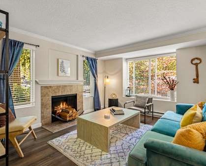 A living room with a fireplace and a green couch.