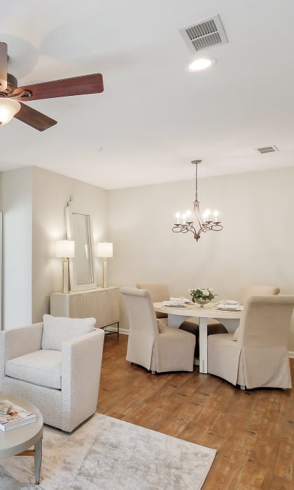 A living room with a white couch, a coffee table, and a ceiling fan at Legacy Apartment Homes in Ridgeland, MS