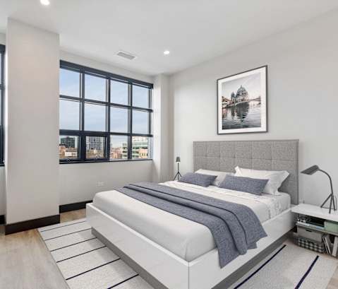 a bedroom with a bed and a large window