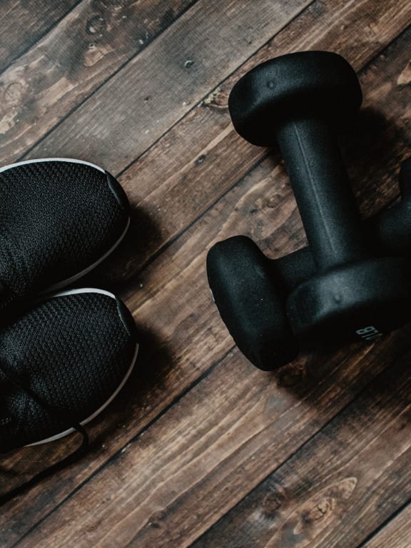 a pair of shoes and a dumbbell on a wooden floor