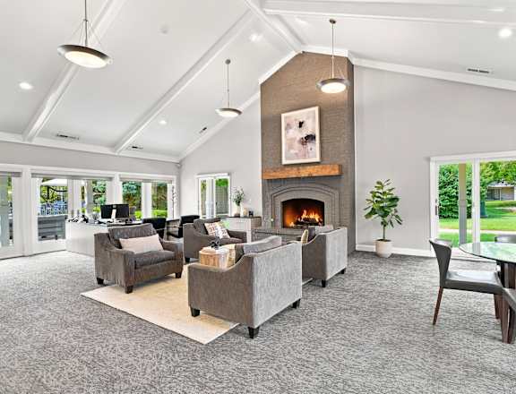 A living room with a fireplace and grey couches.