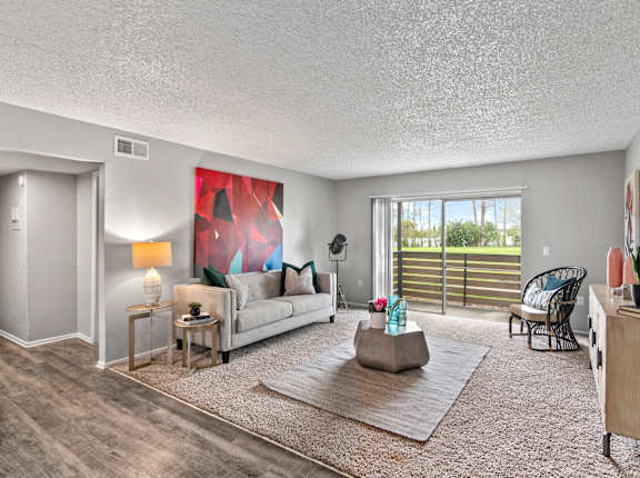 a living room with a couch and a chair and a sliding glass door
