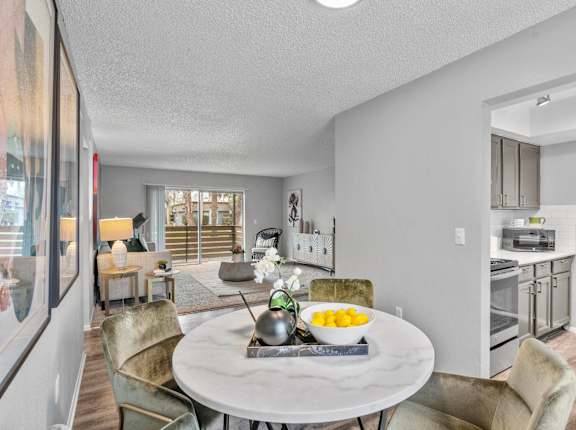 a living room and dining room with a table and chairs and a kitchen
