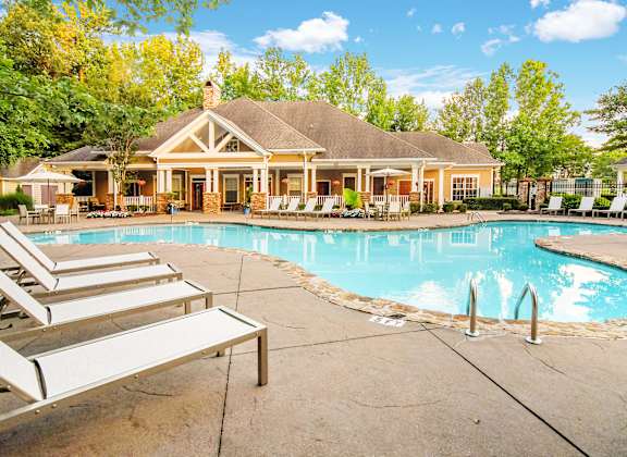 A house with a pool in front of it.