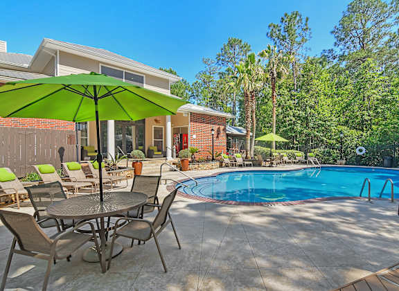 our apartments have a large pool and patio with chairs and umbrellas