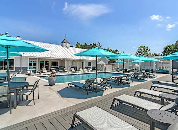 a swimming pool with chairs and umbrellas at the resort at governors club