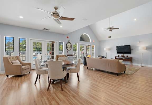 A spacious living room with a large couch, chairs, and a television.