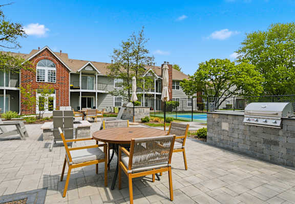 A patio with a table and chairs is in front of a building.