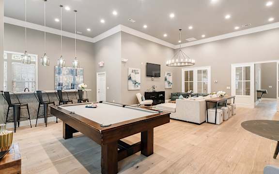 an open living room with a pool table and a dining room