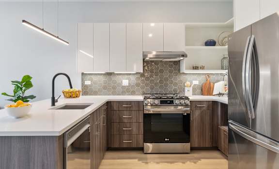 a kitchen with white cabinets and stainless steel appliances