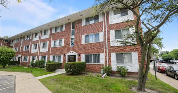 a brick apartment building with a sidewalk in front of it