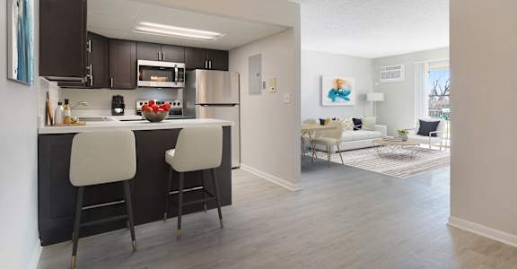 an open kitchen and living room with a dining area and a couch