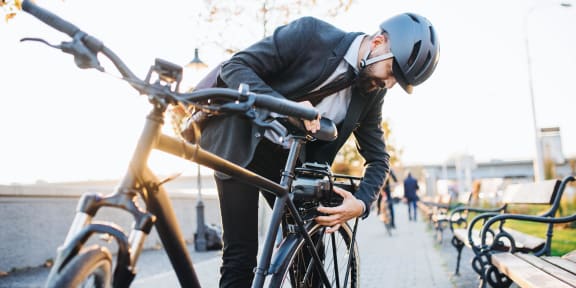 a man in a suit and helmet getting on a bike