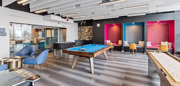 a game room with a pool table and tables