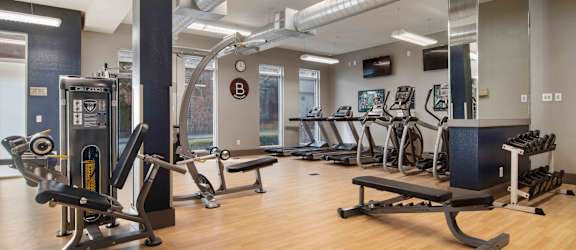 a gym with weights and other exercise equipment on a wooden floor
