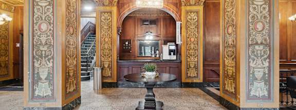 a lobby with a table in the middle of a room at CWE Apartments, St. Louis, 63108