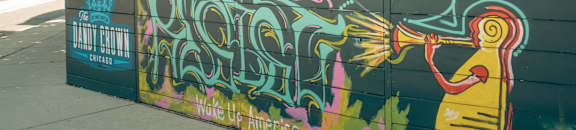 A wall with graffiti and a sign that says "Wake Up America".
